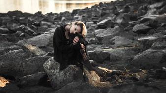 Girl Sad on stones coast