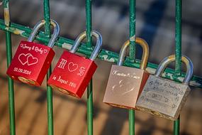 four love lock with engravings on green fence