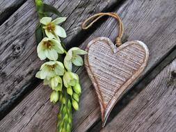 wooden heart and white flowers as a symbol of romance