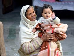 elderly dark skin tribal woman holds Cute Baby Boy