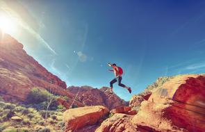 man jumping in the mountains on a sunny day