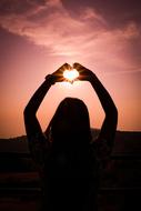 silhouette of a girl with a heart in her hands