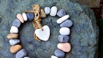 Beautiful and colorful stones with heart and cord, on the rock