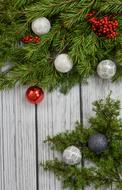 spruce branches with balls on wooden background