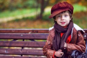 boy on a park bench in autumn