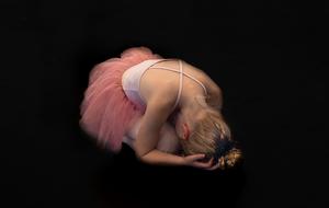 Ballerina, child Girl bended down in darkness