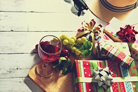 Christmas gifts, grapes and a glass of wine on the table