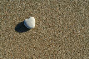 heart shaped stone on the sand