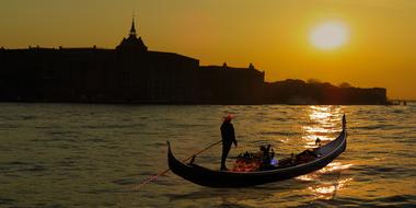 silhouettes of gondolier on the water at dusk