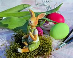Easter rabbit figurine, two colorful eggs and a bouquet of tulips