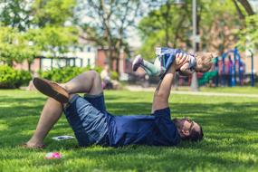 dad and child play on the lawn