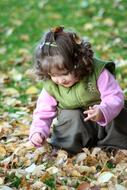 little girl with yellow leaves in the park