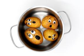 potatoes with faces in a pan