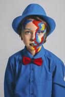 photo of a boy with colorful makeup and a blue hat