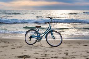 ladies bike stands on Beach at Sea