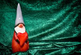 photo of a porcelain figurine of a gnome on a green background