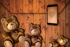 three teddy bears and a tablet