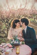 happy young couple in love at table in blooming garden