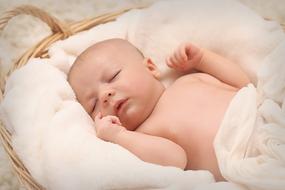 baby sleeps in a wicker cradle