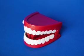 Artificial white teeth at blue Background, digital art