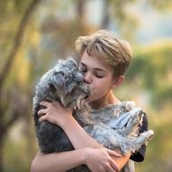 boy kisses a beloved puppy