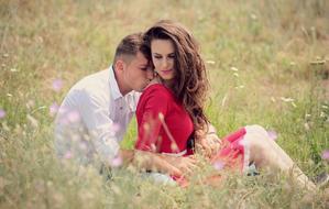 couple in love sitting on a spring blooming meadow