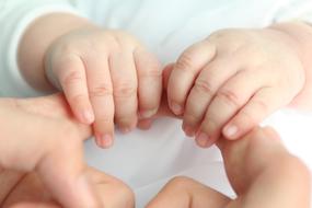 hands of mother and baby close up on blurred background