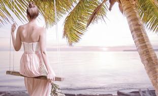 girl on a swing on tropical beach