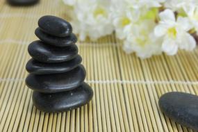 white flowers and a cairn for massage stones