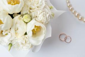 white wedding bouquet and wedding rings