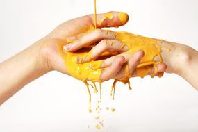 hands of people in yellow paint