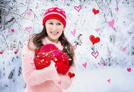 photo of a girl with a heart-shaped gift in the winter forest