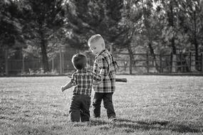 black and white two little brothers walking in the meadow