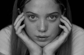 monochrome photo of a girl holding her face with her hands