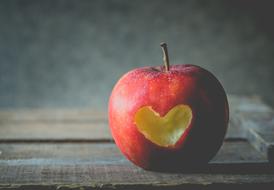 photo of apple with a hole in the form of a heart