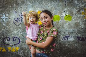 portrait of sisters on the grunge wall background