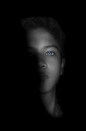 dark photo portrait of a man with blue eyes
