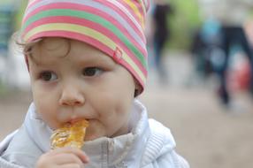photo of a child with a lollipop in his mouth