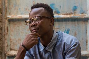 Portrait of Adult african man sitting at grunge wall