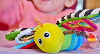 Child near the colorful patterned butterfly toy