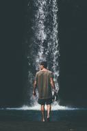 young boy walking to waterfall