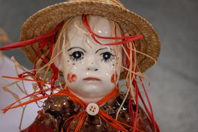 photo of a porcelain doll in a straw hat
