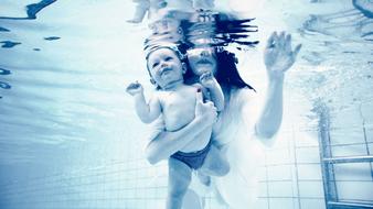 Baby on hand of Mom Underwater