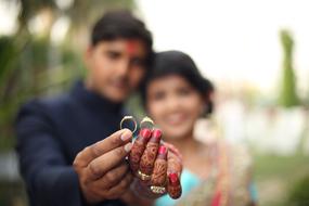 wedding Rings in hands of young indian Couple