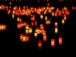 thousands of red candles float in the river