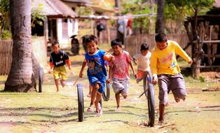 asian child boys Playing with old tires on street in village