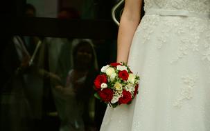 a bouquet of roses in the hands of the bride