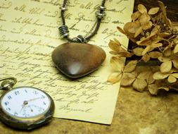 vintage pocket watch and wooden heart on love letter