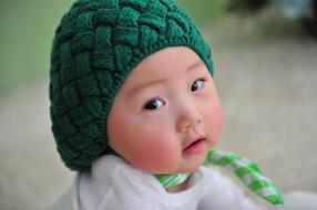 photo of an asian girl in a green knitted hat