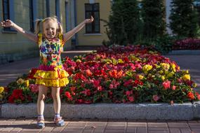 happy child Girl in city at flower bed